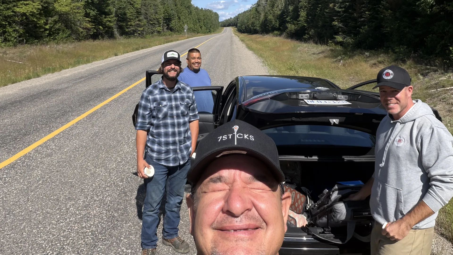 The four-person field team beside their vehicle on the road toward Armstrong